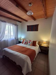 a bedroom with a large bed and a wooden ceiling at Cabañas el Chañar in San Pedro de Atacama +53 photos