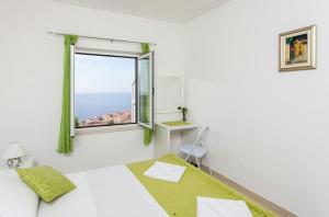 um quarto branco com uma cama e uma janela em Apartment Ivy em Dubrovnik
