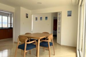 Un comedor con mesa y sillas de madera. en Comodo Apartamento con Terraza Privada, en Sogamoso