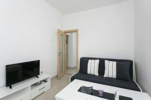 uma sala de estar com um sofá e uma TV em Apartment Ivy em Dubrovnik