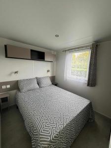 un dormitorio con una cama y una ventana en Mobile home Camping Siblu Les Charmettes 4, en Les Mathes