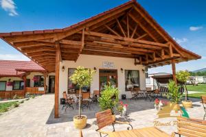 a patio with a wooden pavilion with chairs and tables at Németh Resort in Sovata