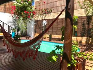 a hammock on a deck next to a pool at Villa Puglia Jeri in Jericoacoara