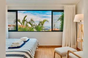une chambre avec un lit avec une grande fenêtre dans l'établissement Casa da Rochinha com piscina privada, à Funchal