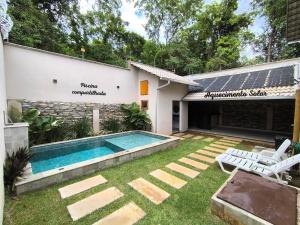 ein Hinterhof mit einem Swimmingpool und einem Haus in der Unterkunft Loft do Fotógrafo 1 - Ao lado do Rio das Almas in Pirenópolis