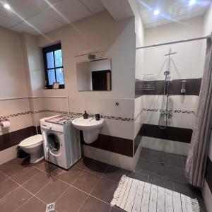 a bathroom with a washing machine and a sink at Къща за гости Belora in Dryanovo