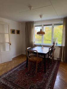 a dining room with a table and chairs at Gårdsflygel med egen trädgård in Lind