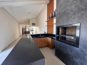 a kitchen with a black counter top and a sink at Casa dos sonhos em Ribeirão Claro, PR in Ribeirão Claro