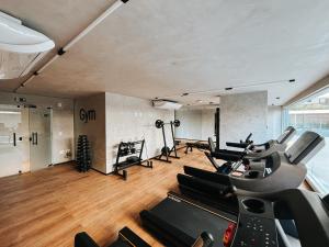 a gym with treadmills and ellipticals in a room at Studio Premium Batista Campos in Belém