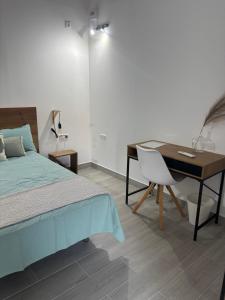 a bedroom with a desk and a bed and a desk and chair at Origen Bed and Breakfast in Villargordo del Cabriel
