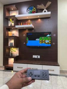 a person holding a video game controller in front of a tv at Shivalay - By Safarnama Stays - Near Kashi Vishwanath in Varanasi