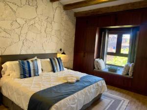 a bedroom with a bed and a stone wall at Solange Suite en ValQuirico in Santeagueda