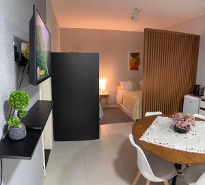 a living room with a table and a bedroom at Loft veraneio in Balneário Camboriú