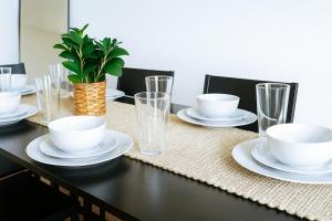a table with plates and cups and a plant on it at Spacious 2BR Loft - near CSU, Playhouse, Progressive field, R&R Hall of Fame - Gym & Sauna in Cleveland +11 photos