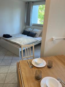 a room with a bed and a table with plates on it at SEEnah Ferienwohnung in Überlingen