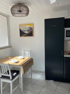 a kitchen with a wooden table and a black refrigerator at SEEnah Ferienwohnung in Überlingen