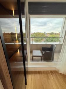 Habitación con ventana, silla y mesa. en Apartment UNA, en Pančevo