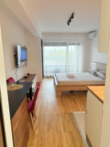 Habitación pequeña con cama, escritorio y escritorio. en Apartment UNA, en Pančevo