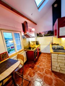 a kitchen with a sink and a table in it at Gites Le Roosevelt - Côte 204 in Château-Thierry