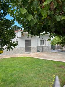 a white house with a gate and a yard at H&V suite home in Paralía Avlídhos