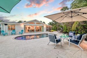 a patio with a table and chairs and an umbrella at Beach Palm Villa - 5533 in Siesta Key