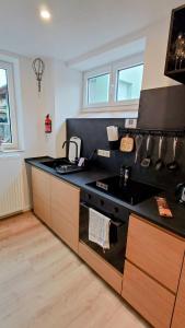 a kitchen with a black counter top and a sink at alte Bäckerei Ottendorf-Okrilla #Fritz# in Ottendorf-Okrilla