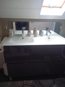 a bathroom with a sink with two faucets at Loue chambre in Le Mans