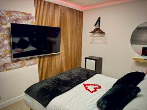 a bedroom with a bed with a tv on the wall at Suite 1 Private Jacuzzi Spa Hot Tub & Sauna in Attercliffe