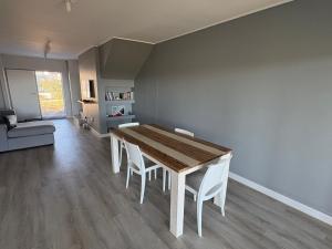 a dining room with a wooden table and white chairs at Townhouse in Stellenbosch in Stellenbosch +2 photos