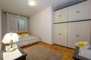 a bedroom with a bed and a desk with a lamp at Apartments Rasic in Palit
