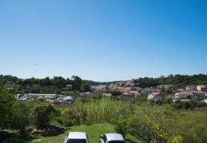 two cars parked on a hill with a city in the background at Apartments Rasic in Palit +43 photos
