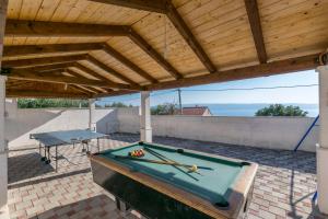 a pool table on a patio with a wooden roof at Villa Leo in Krilo