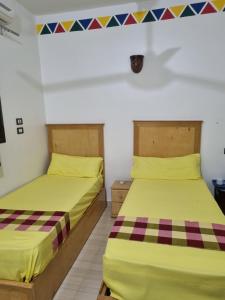 two beds in a room next to each other at ABAZIDO Nubian Guest House in Aswan