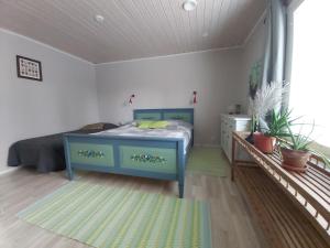 a bedroom with a blue bed in a room at Guesthouse Northern Star in Muonio