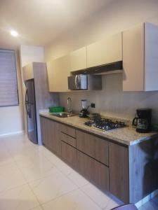 a kitchen with wooden cabinets and a counter top at A beautiful apartment, in the heart of the golden zone! in Mazatlán