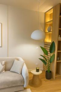 a living room with a couch and a potted plant at Belgrade Waterfront Nostra Casa in Sajmište