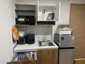 Ban Pra DokにあるCaesar's Suite Condo Koratのシンクと冷蔵庫のある小さなキッチン