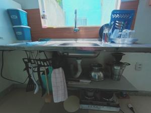 a kitchen counter with a sink under a window at Apartamento Próximo a Pituba in Itacaré