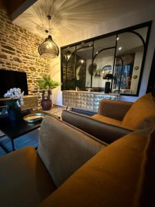 Una sala de estar con dos sofás y una chimenea. en Ecrin de Charme, en Granville