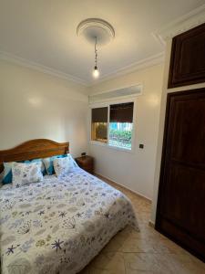 a bedroom with a bed and a window at Étoile de la mer in Ksar es Sghir