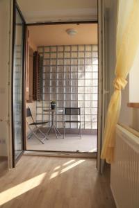 a sliding glass door leading into a room with a table at Mo Apartman in Budapest