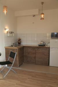 a kitchen with a white refrigerator and a chair at Mo Apartman in Budapest