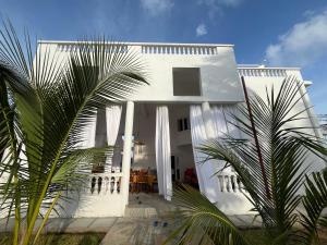 ein weißes Haus mit einer Palme davor in der Unterkunft Mambrui Holiday Villa Nyumba Nane in Malindi