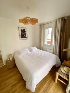 a bedroom with a white bed and a window at Coconing Plage Pléneuf Val André in Pléneuf-Val-André