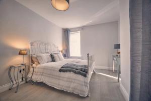 a white bedroom with a bed and a window at Roselyn By The Sea - Pet Friendly Accommodation in Newbiggin-by-the-Sea