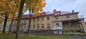 イェレニャ・グラにあるSTREFA ZEN Klimatyczny Pokoj przy Parkuの正面に看板がある大きな建物