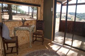 a room with a table and chairs and a window at Dargle Forest Lodge in Dargle