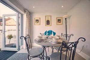 a dining room with a table and chairs and a window at Roselyn By The Sea - Pet Friendly Accommodation in Newbiggin-by-the-Sea +9 photos