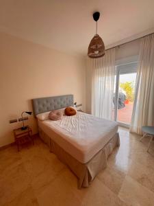 a bedroom with a bed and a large window at Ático con vistas al mar y terraza in Alcaidesa