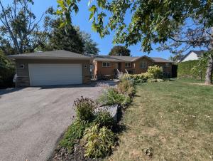 a house with a garage in a yard at Red Brickhouse Lakefront Cottage in Brechin